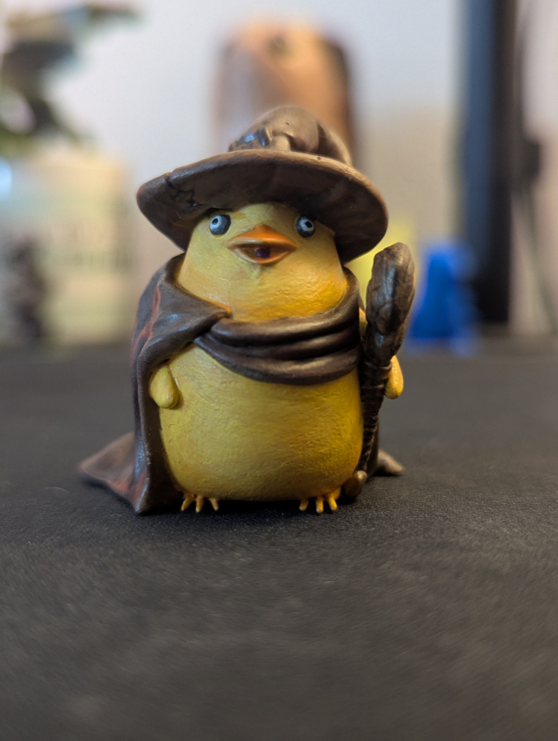 A hand painted yellow duck wearing a wizards cloak and hat